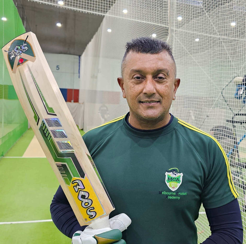 Reserve Edition Players Grade English Willow Cricket Bat held by a cricketer in a training facility.