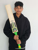 Custom made cricket bats held by a young player in a black hoodie, showcasing its vibrant design and grip.