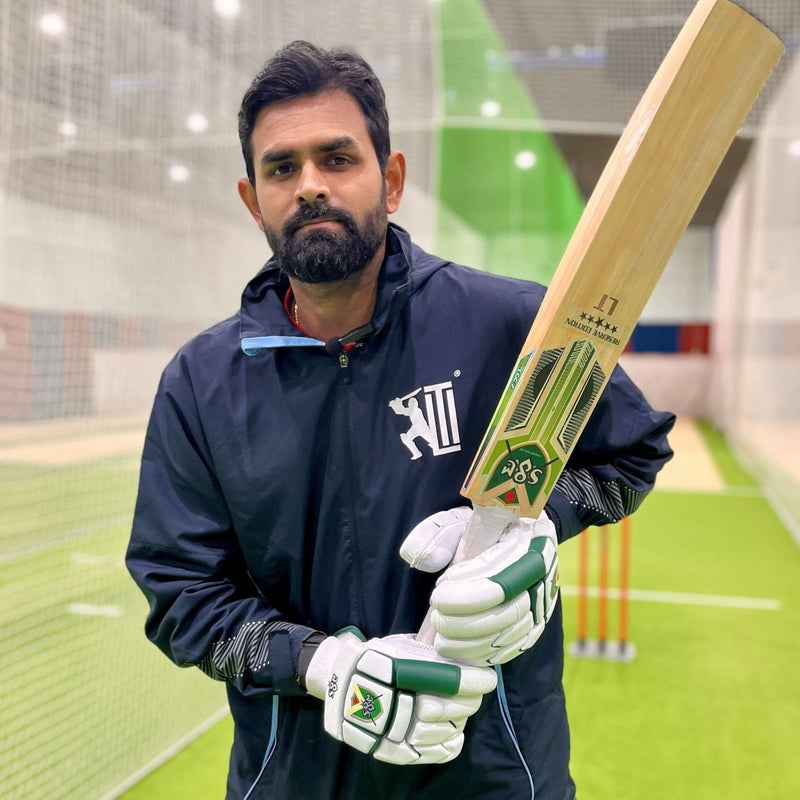 Reserve Edition Players Grade English Willow Cricket Bat held by a cricketer in training facility.